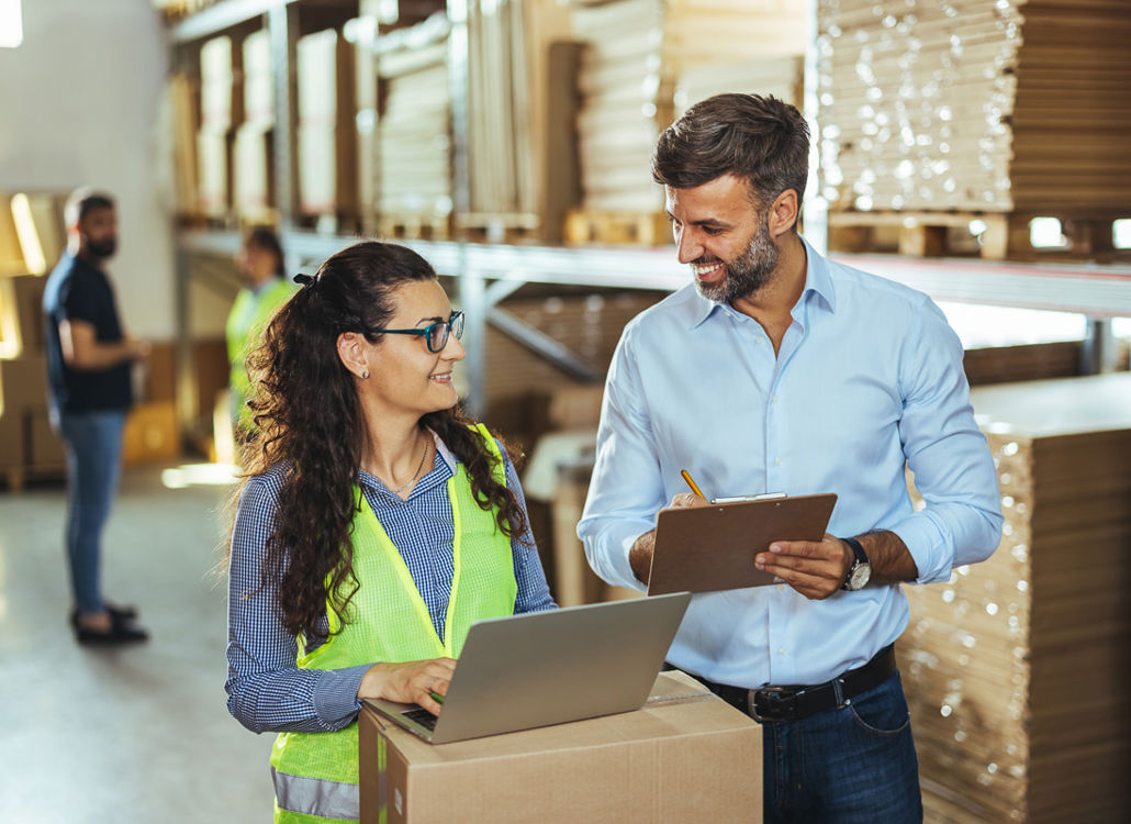 Logistics and warehouse employees coordinating shift scheduling and time tracking to support efficient staffing and daily operations.
